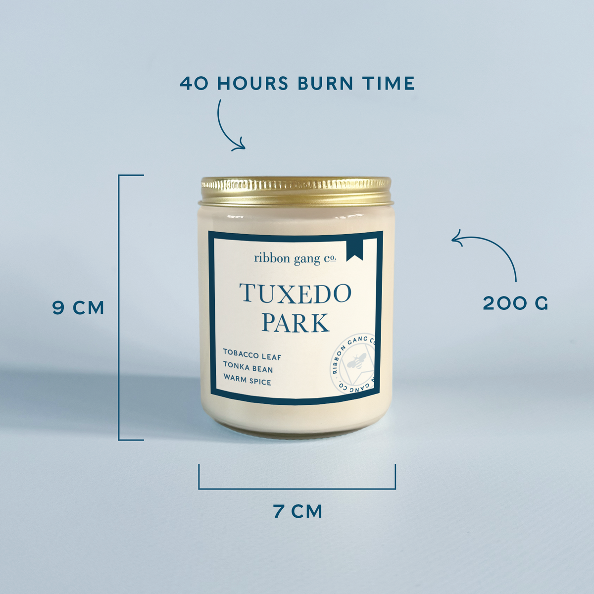A jar candle labeled 'ribbon gang co. TUXEDO PARK' centered on a light blue background with measurement callouts showing 9 cm height, 7 cm width, 200 g weight, and 40 hours burn time.