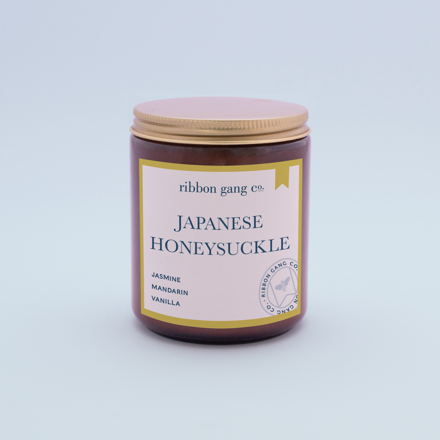 Japanese Honeysuckle Candle in an amber jar with a gold lid