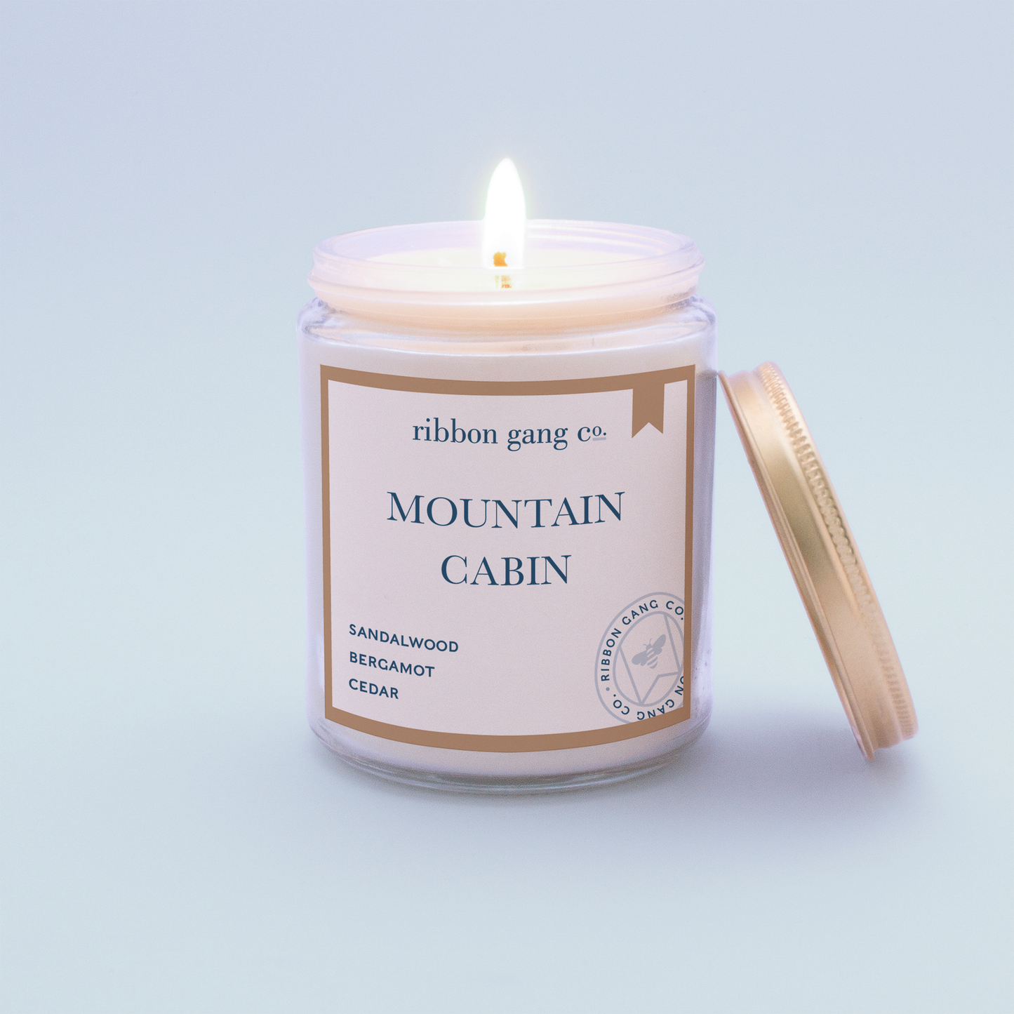 Mountain Cabin candle burning in a clear jar