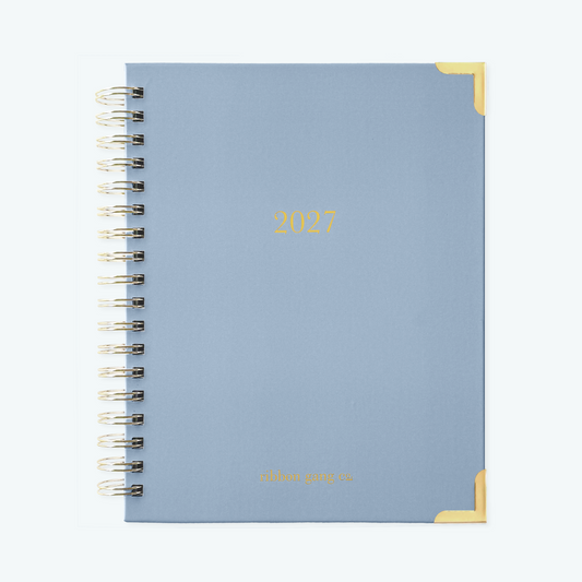 French blue spiral bound 2027 planner with gold lettering and gold corners on a white background.