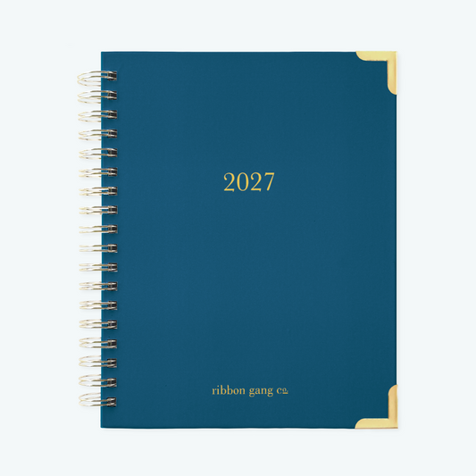 A navy blue spiral bound 2027 planner with gold lettering and gold corners on a white background.