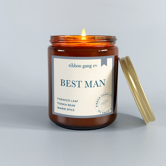 Candle with 'Best Man' label from Ribbon Gang Co. on a gray background.