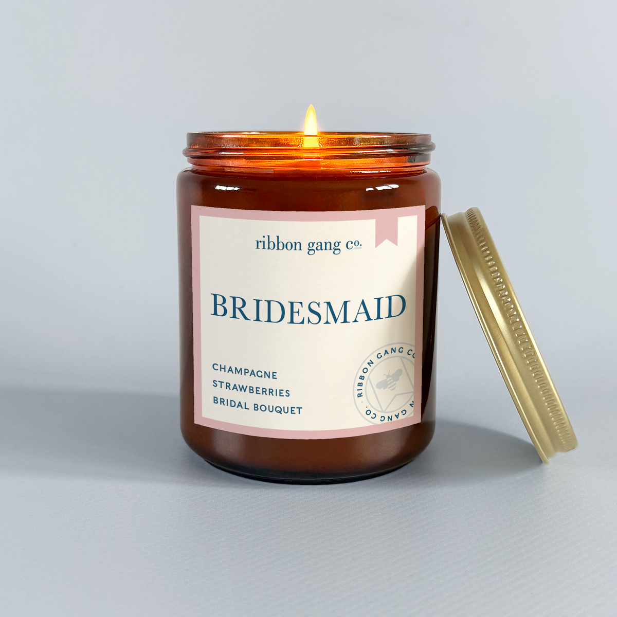 Candle with 'Bridesmaid' label from Ribbon Gang Co. on a gray background.