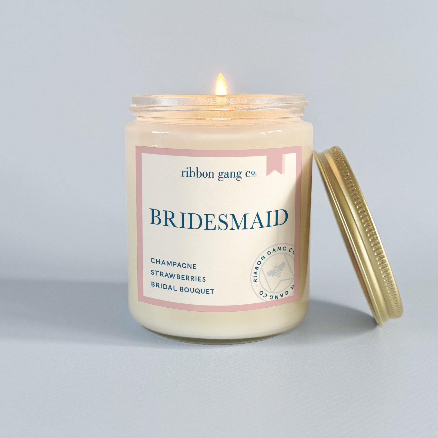 Bridesmaid candle with 'ribbon gang co.' label on a gray background.
