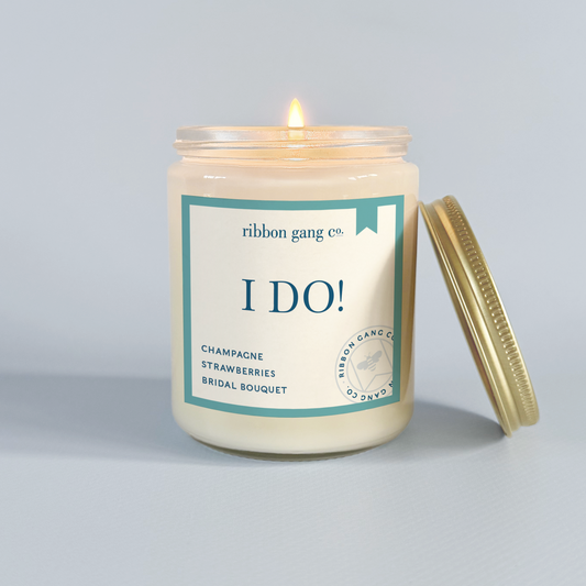 Candle with 'I Do!' label from Ribbon Gang Co. on a grey background.