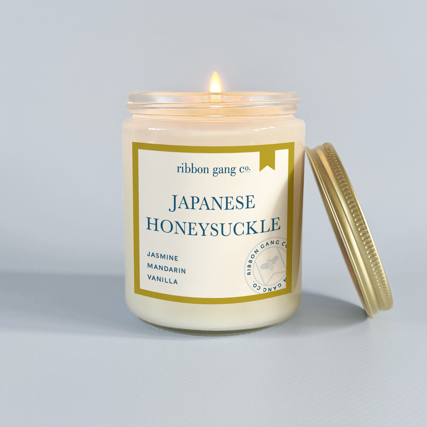 Candle with 'Japanese Honeysuckle' label on a grey background.