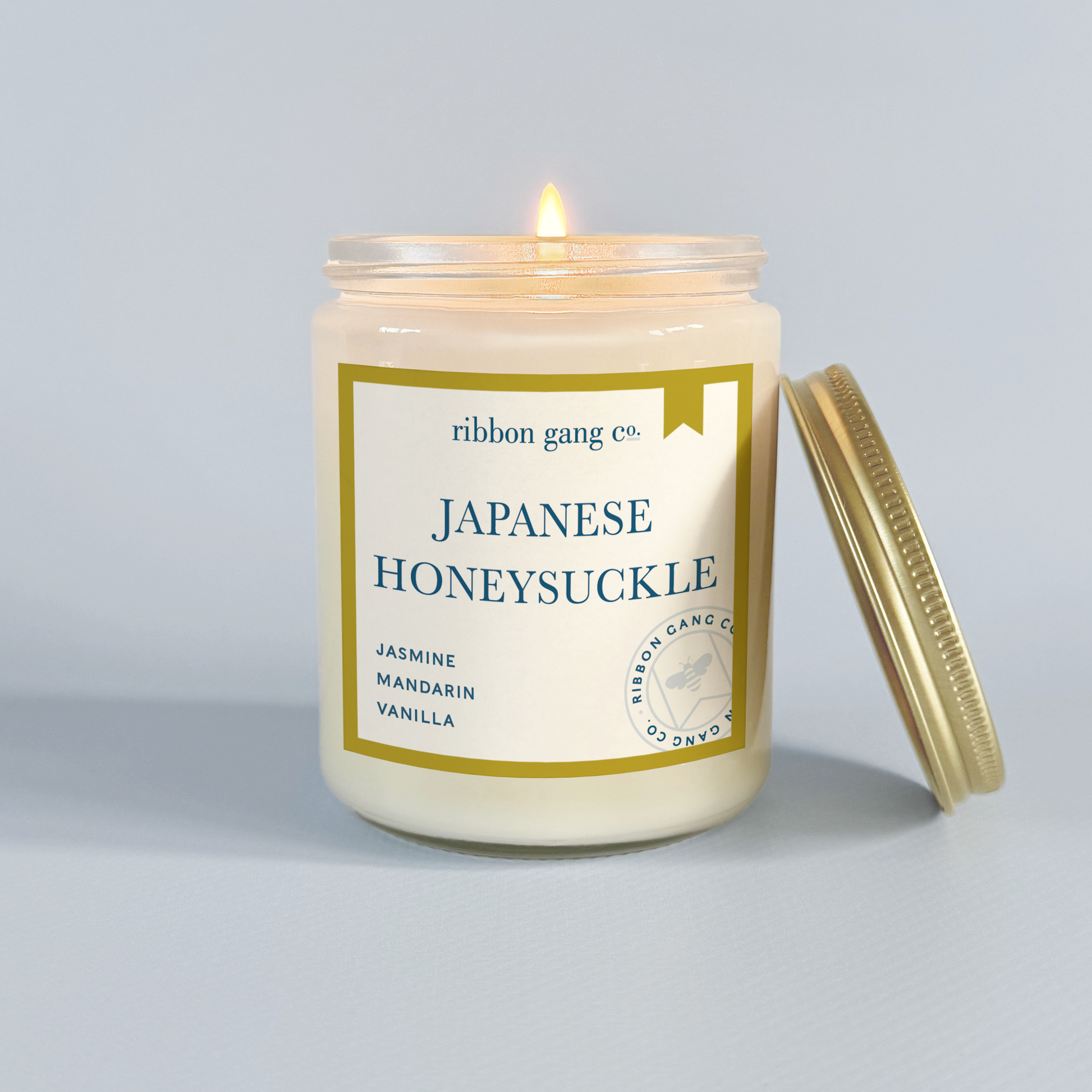 Candle with 'Japanese Honeysuckle' label on a grey background.