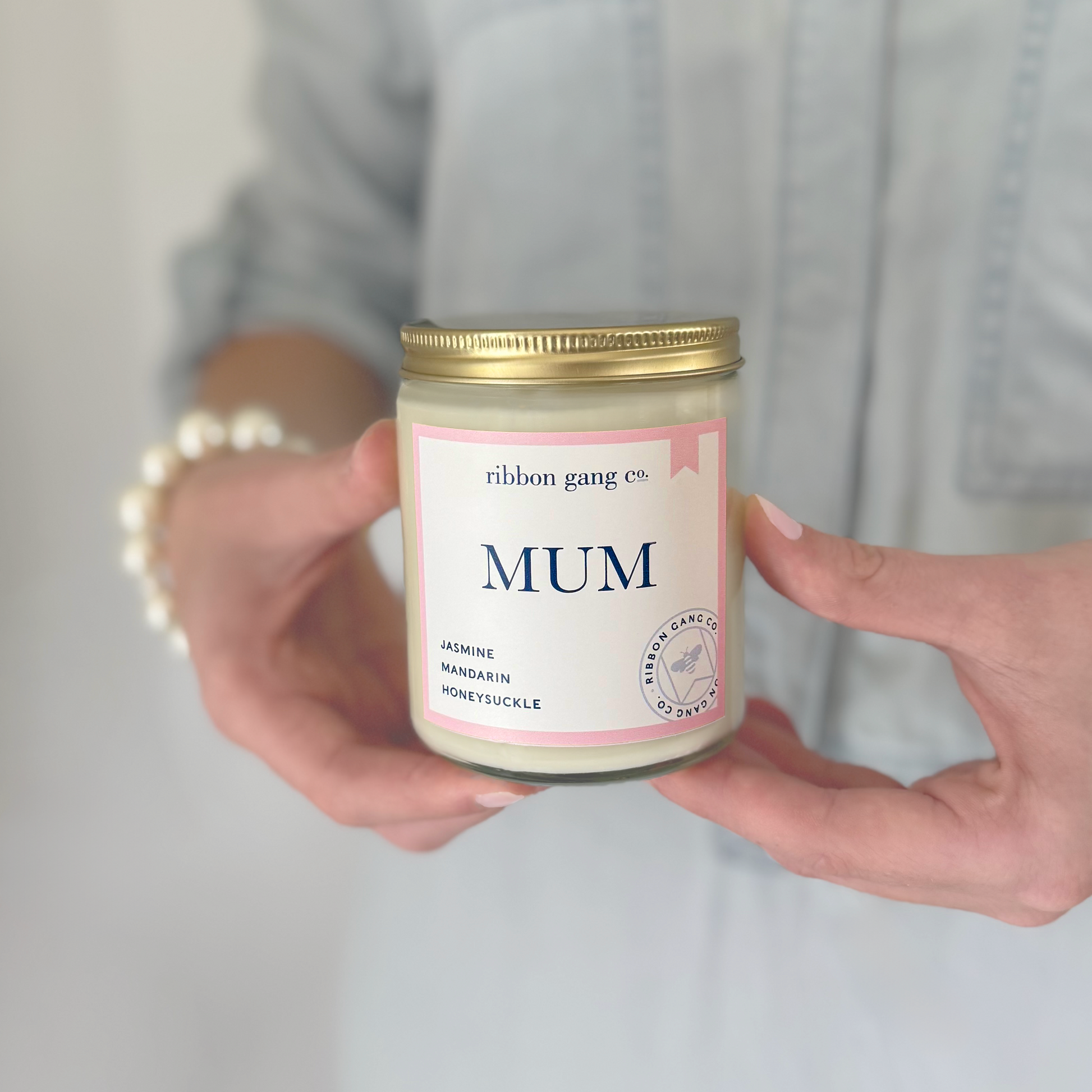 Person holding a candle labeled 'Mum' by Ribbon Gang Co.