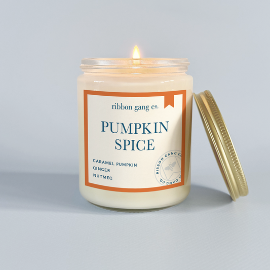 Pumpkin spice candle with a visible label on a grey background.